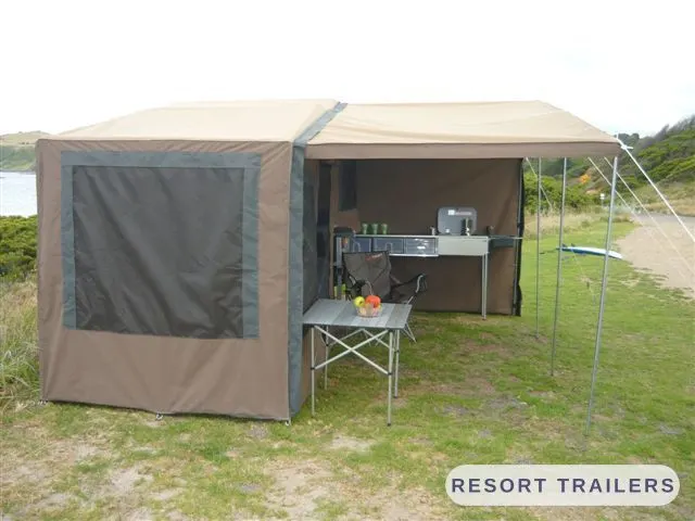 Annexe and slide-out kitchen set up beside the camper — built by Resort Trailers