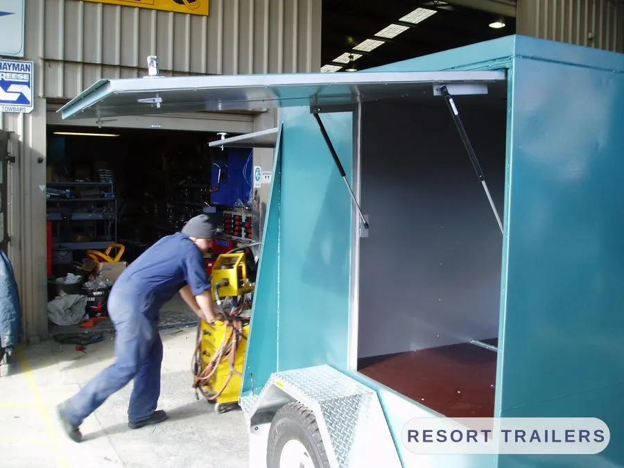 Gull-wing panel raised on an enclosed trailer — built by Resort Trailers