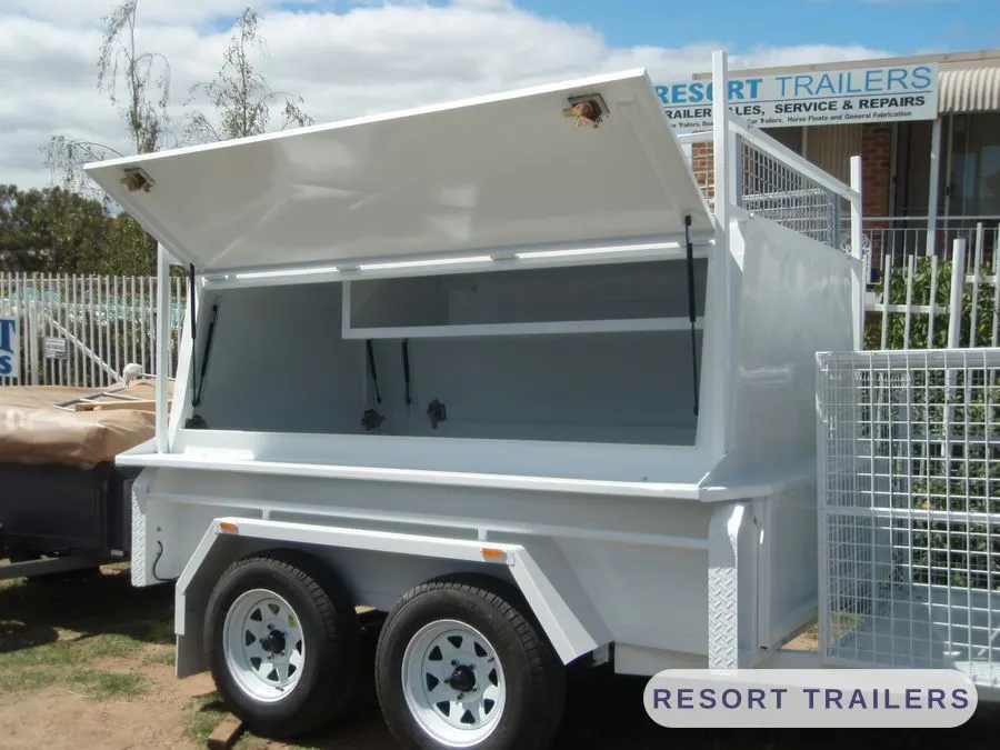 White canopy trailer with a mesh cage and the lid open — built by Resort Trailers